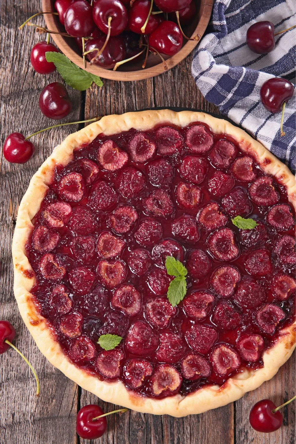 a pie crust filled with halved cherries