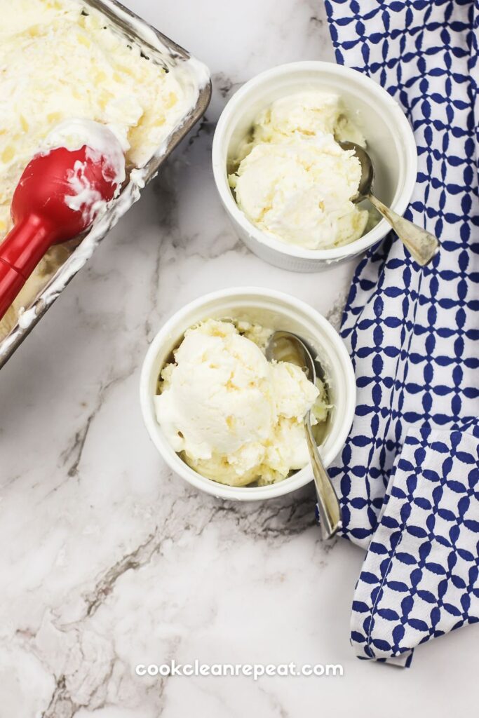 two bowls of pineapple ice cream with the loaf pan and scoop beside them