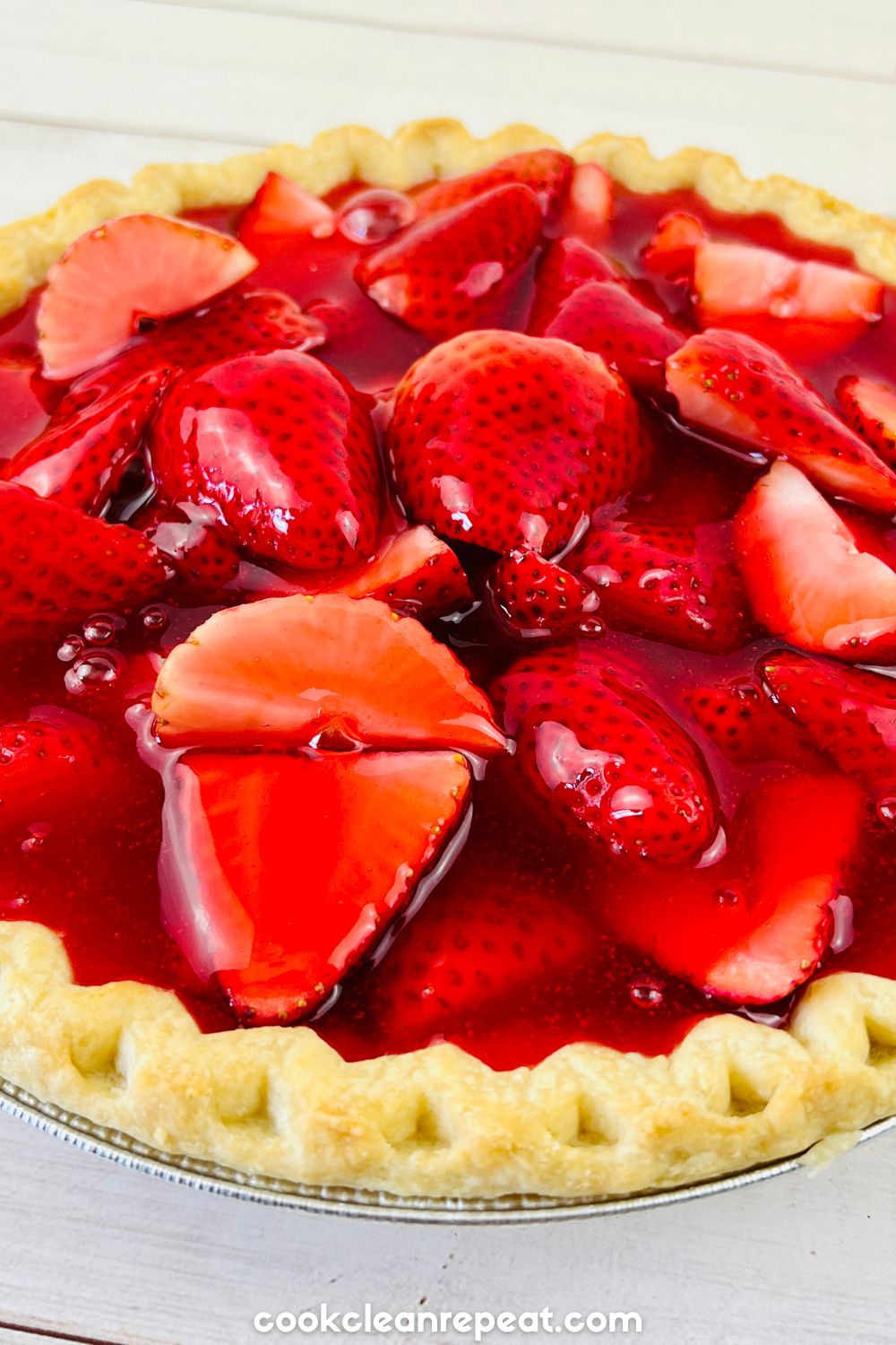 fresh cut strawberries in a pie crust with jello poured on top