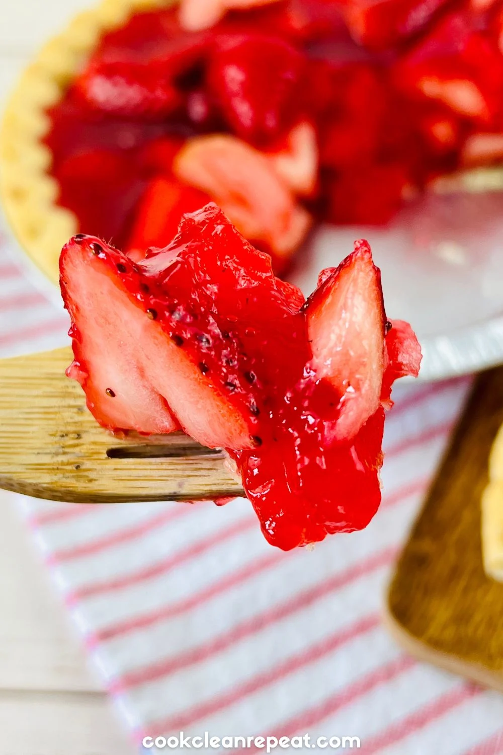 a fork holding a piece of the strawberry pie