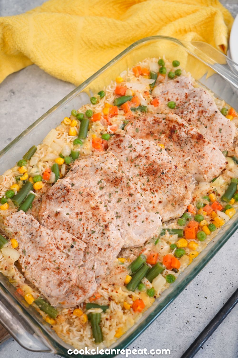 pork chops and vegetables in a clear baking dish