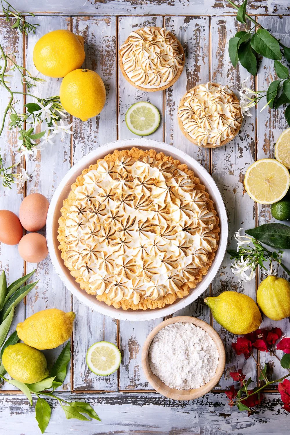 a lemon pie from above surrounded by ingredients and lemons