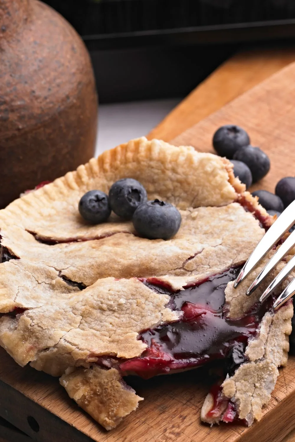 a fork digging into a blueberry pie