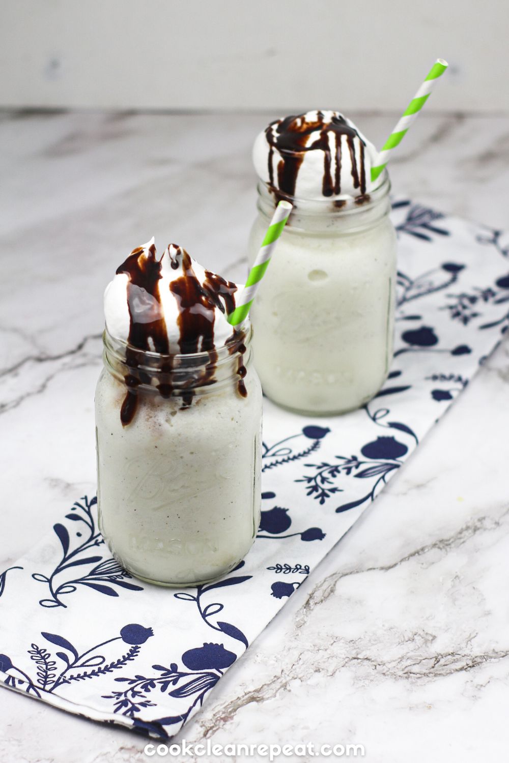 two servings of starbucks vanilla frappuccino in mason jars with green and white straws