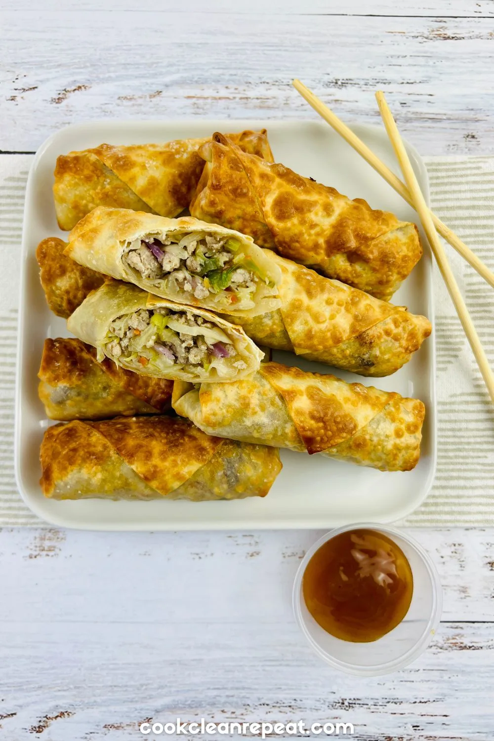egg rolls on a plate with two of them positioned to see the ingredients inside