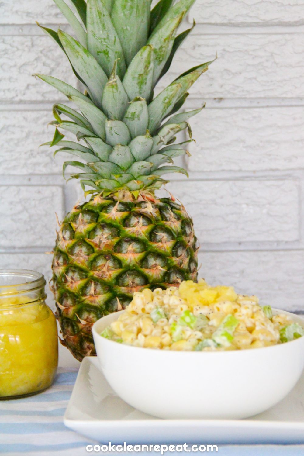 pineapple pasta salad styled with a full pineapple and crushed pineapple