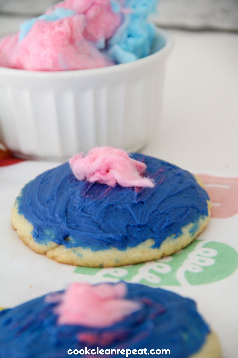 cookies covered with blue icing and a pink piece of cotton candy on top