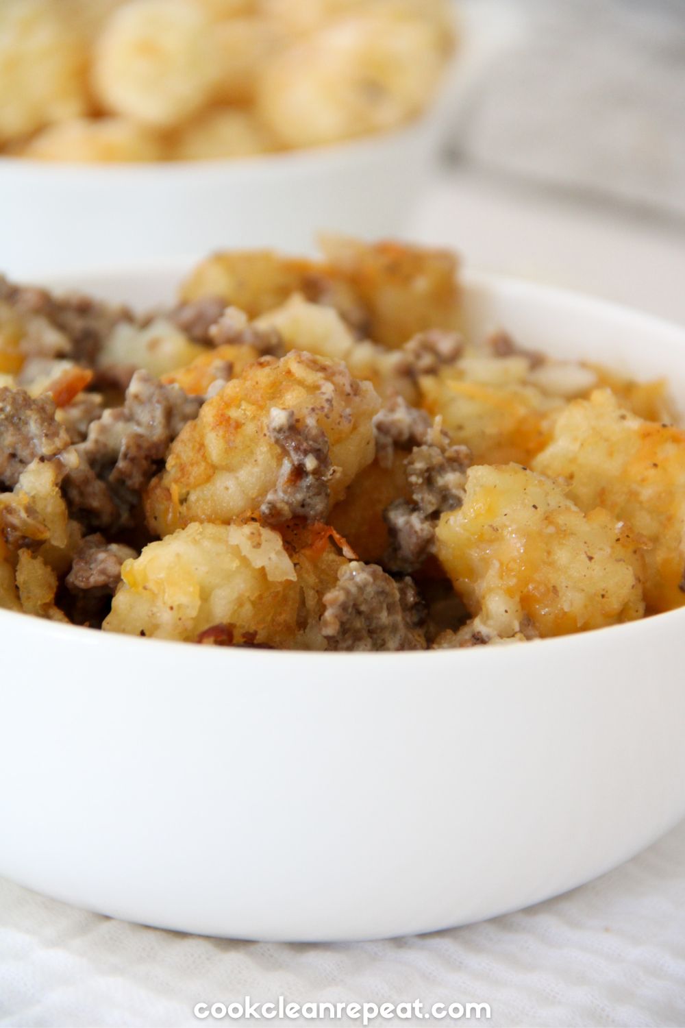 tater tot casserole in a white bowl from the side