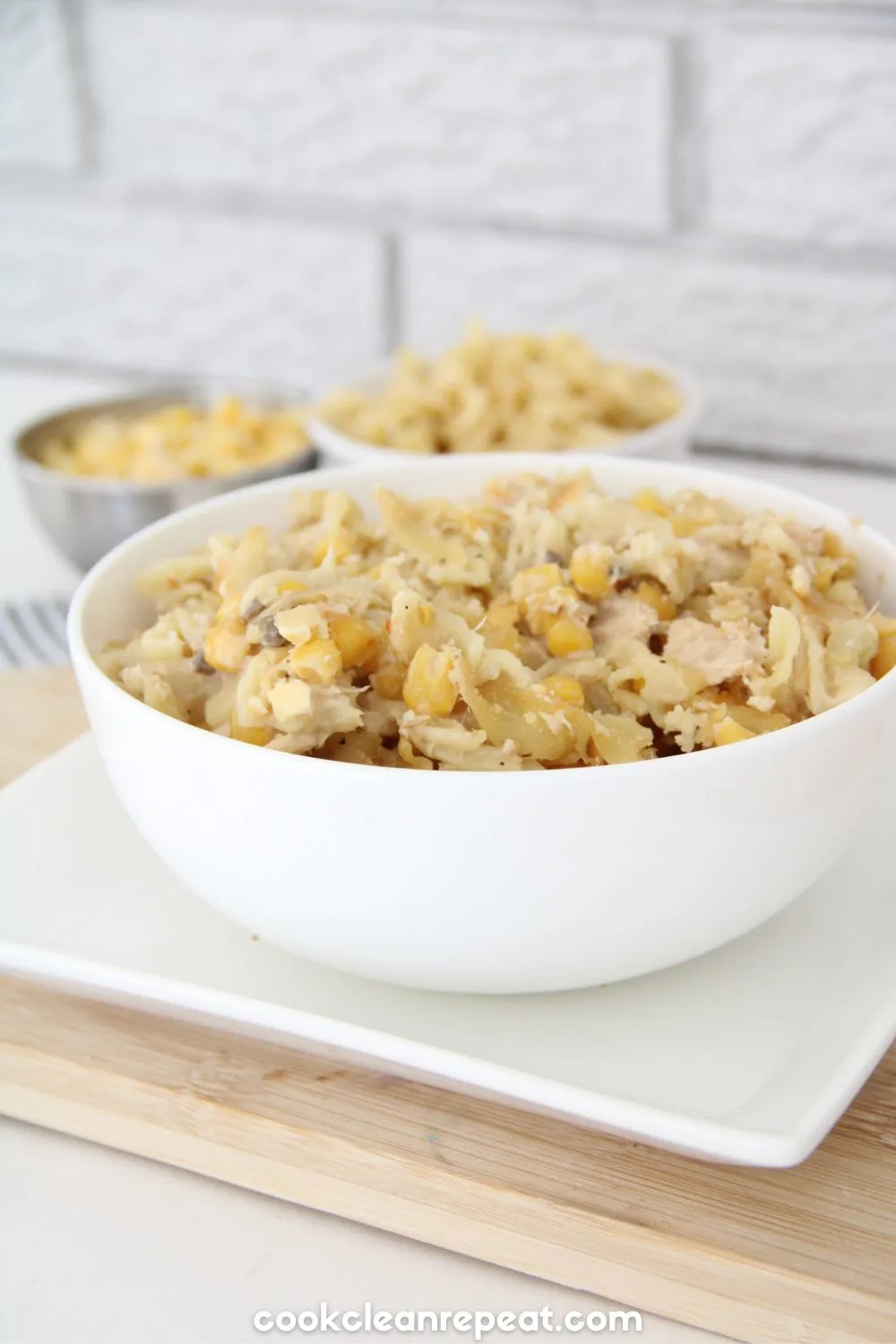 Tuna Casserole Recipe styled in a white bowl with two bowls in the background