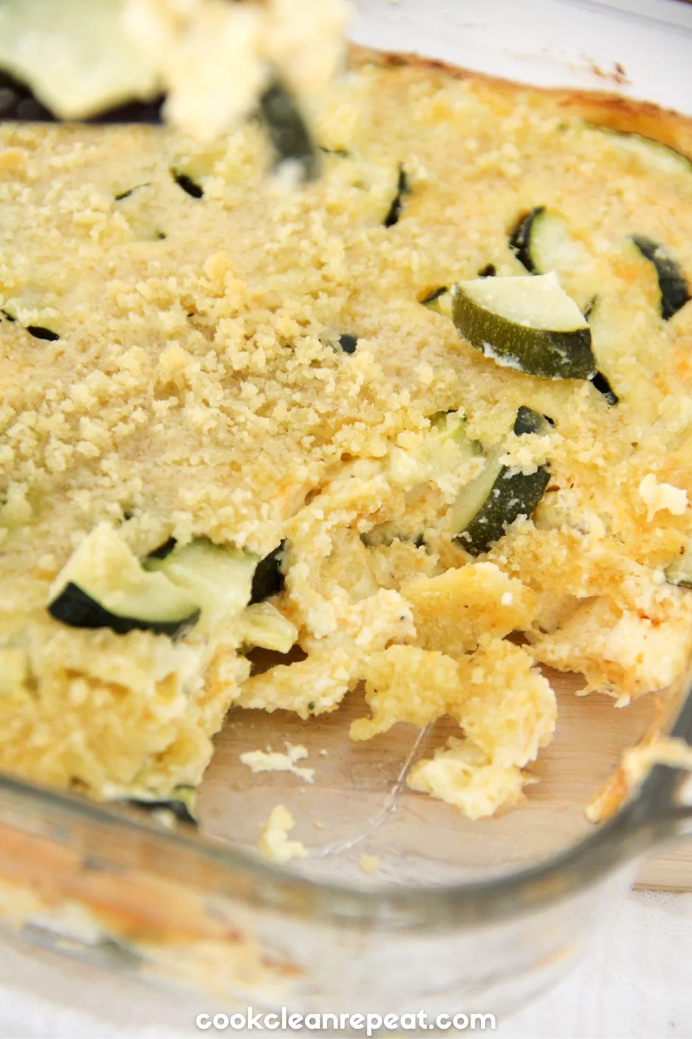 Zucchini Casserole in a casserole dish with a piece taken out of the corner