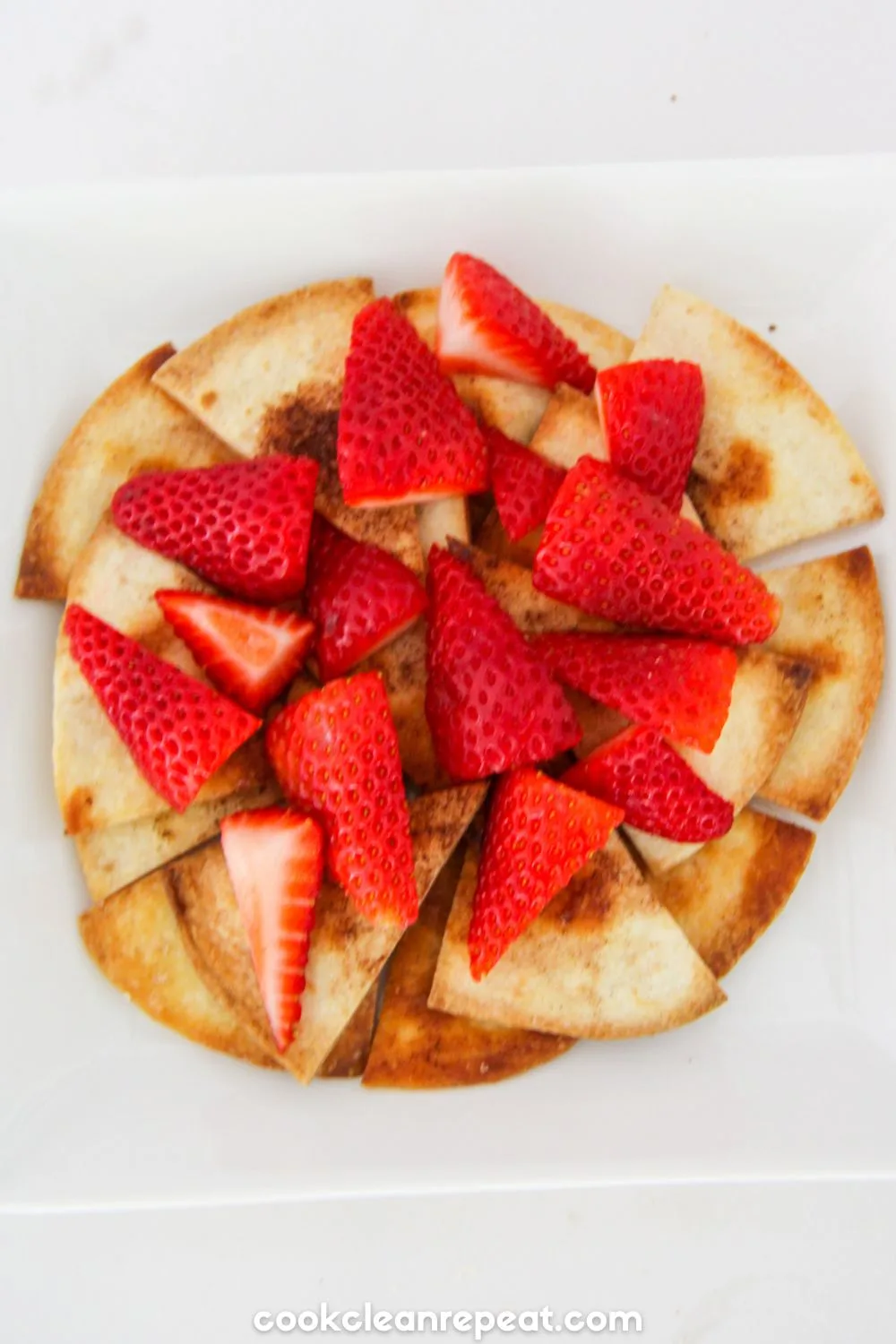 tortilla pieces on a plate with strawberries on top