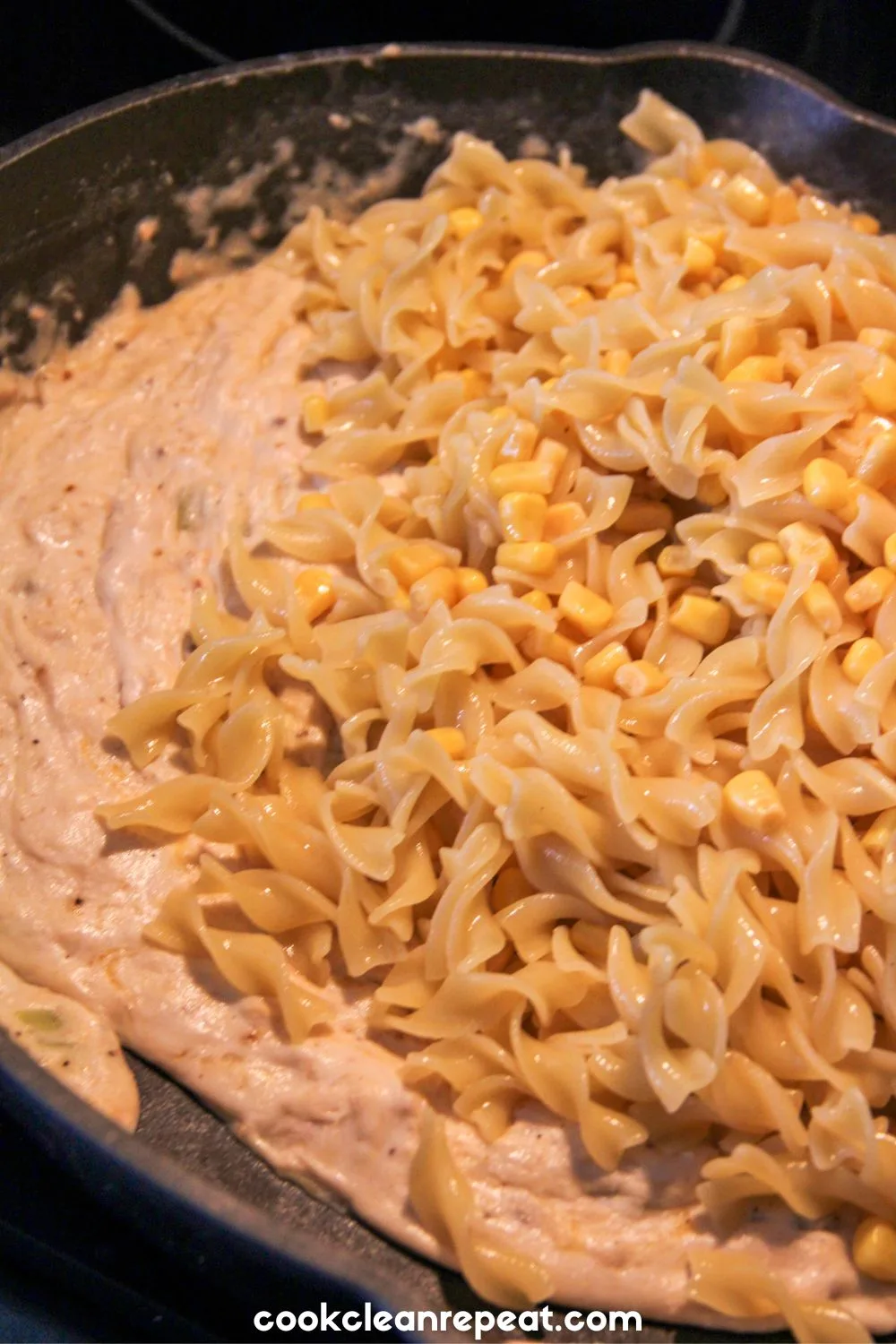 pasta being mixed into creamy casserole filling