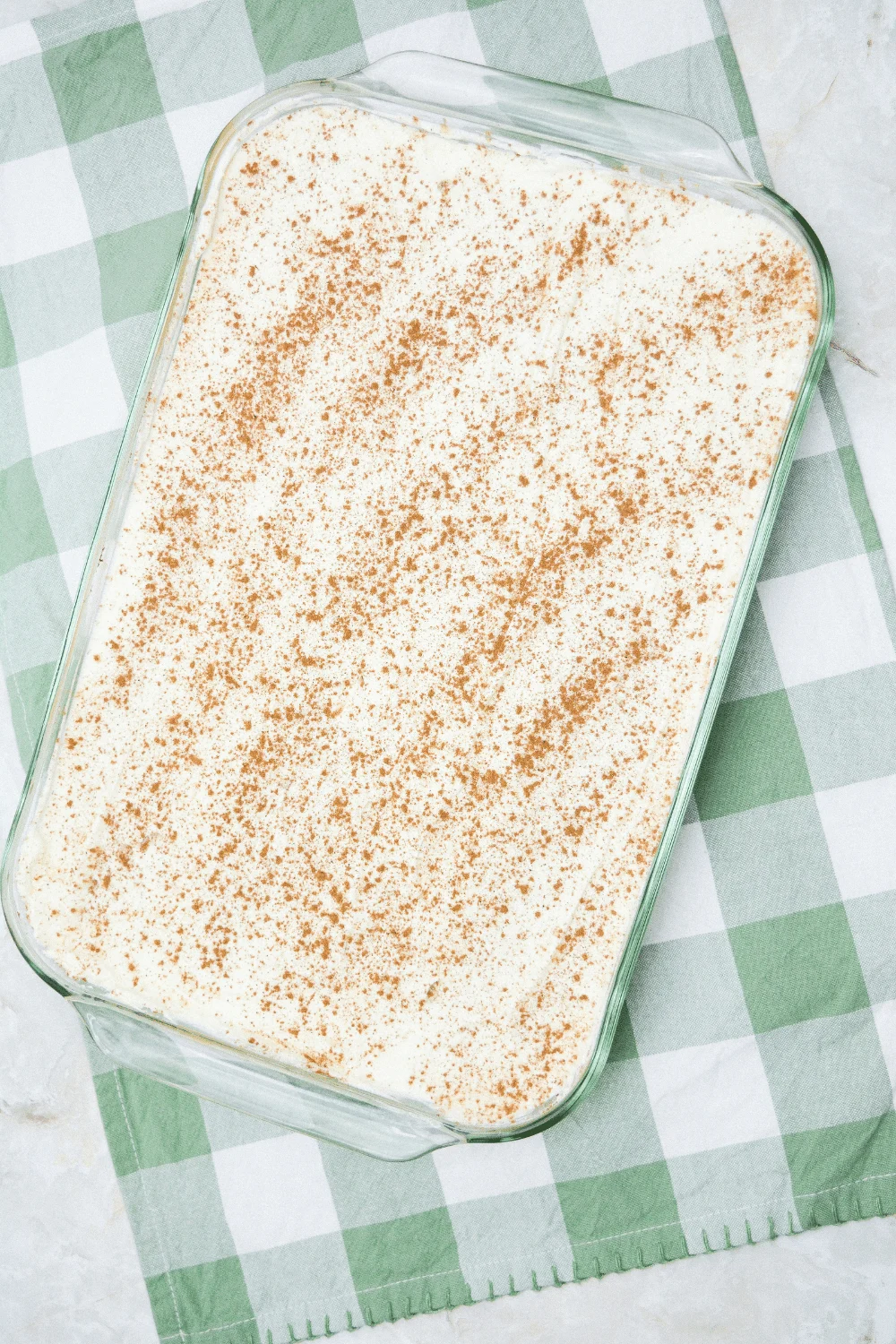 cinnamon sprinkled on top of whipped cream and pumpkin layers for no bake pumpkin icebox cake recipe