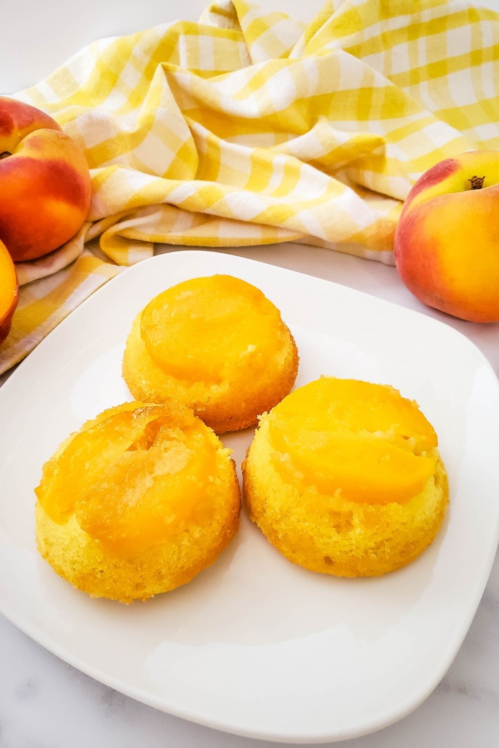 Three peach upside down cupcakes on a plate