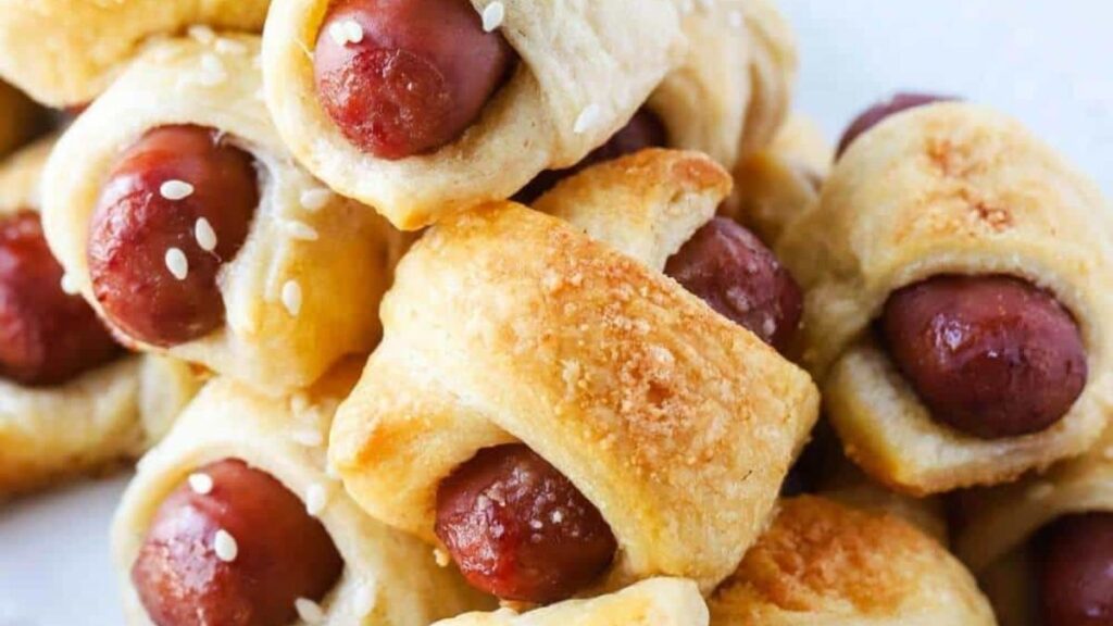 Pigs in blankets with sesame seeds over top.