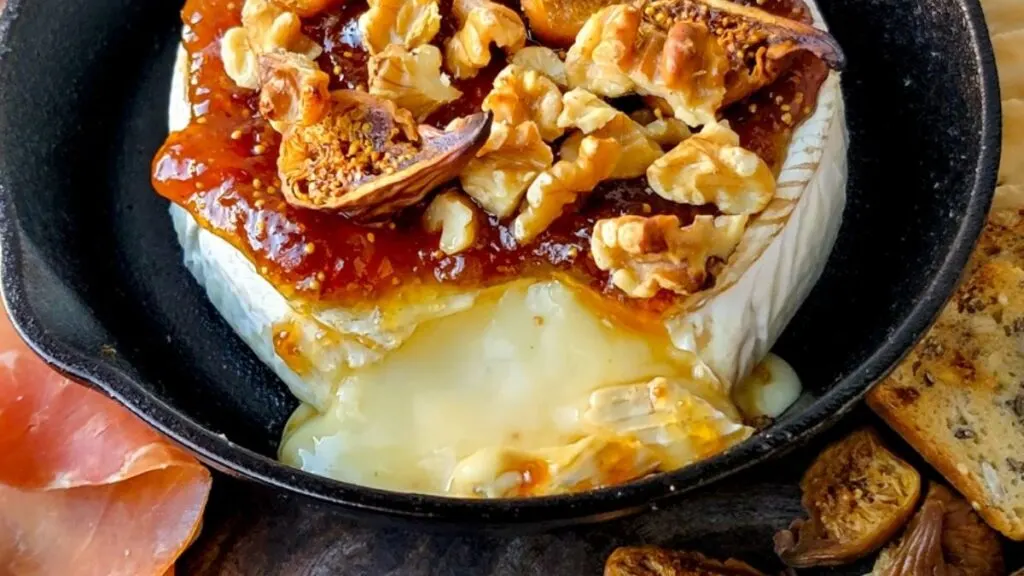 A skillet of baked brie with jam.
