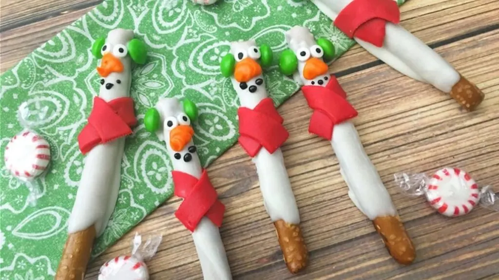 Snowman pretzel rods with red candy scarves.