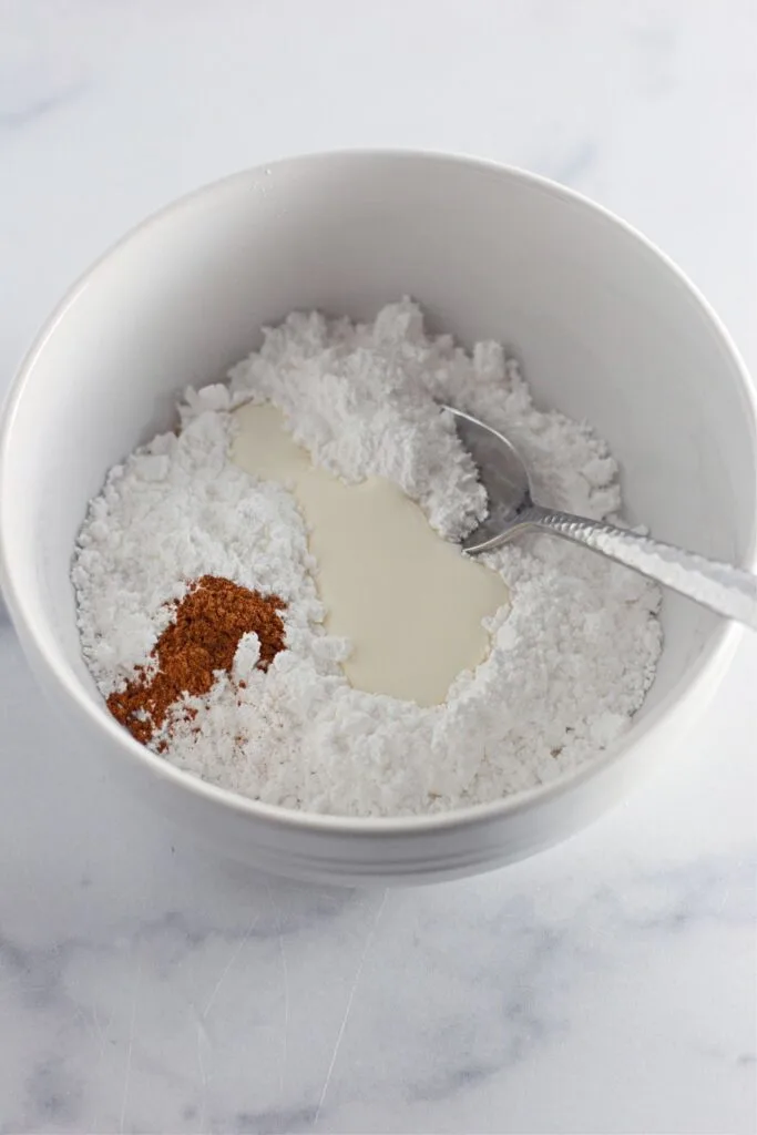 icing ingredients added to a bowl