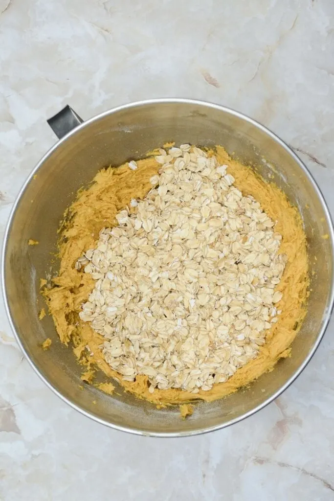 oats are added to mixing bowl with cookie batter