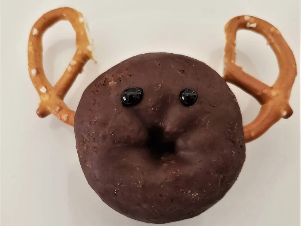 chocolate donut with pretzel antlers and black gel where the eyes will go