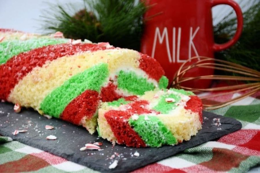 A candy cane cake roll sliced on a plate.