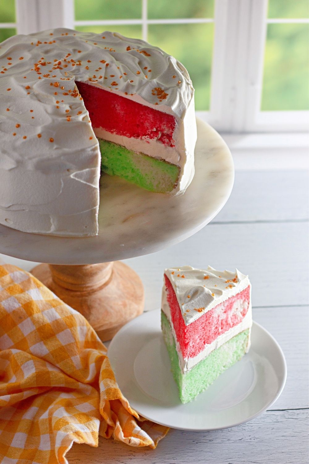 A red and green Jello cake sliced with a view inside