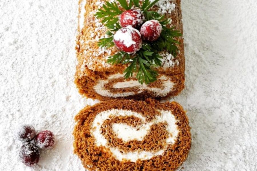  A gingerbread sponge cake with eggnog whipped cream, with sugared cranberries on the top.
