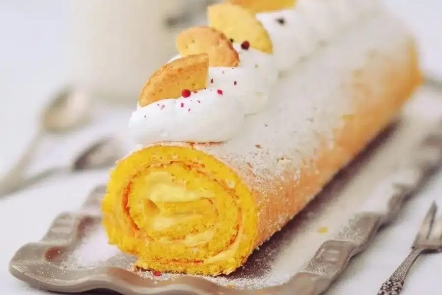A cake roll made with lemon curd, with cookie garnish.