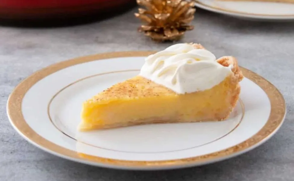 A slice of eggnog custard pie with whipped cream.