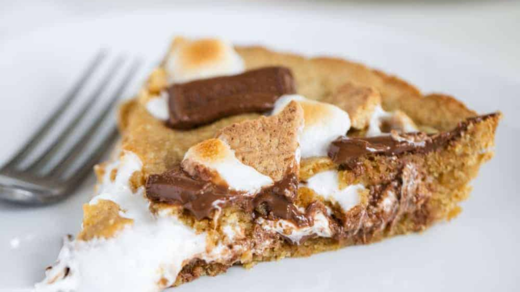 slice smores pie with roasted marshmallows and chocolate on top