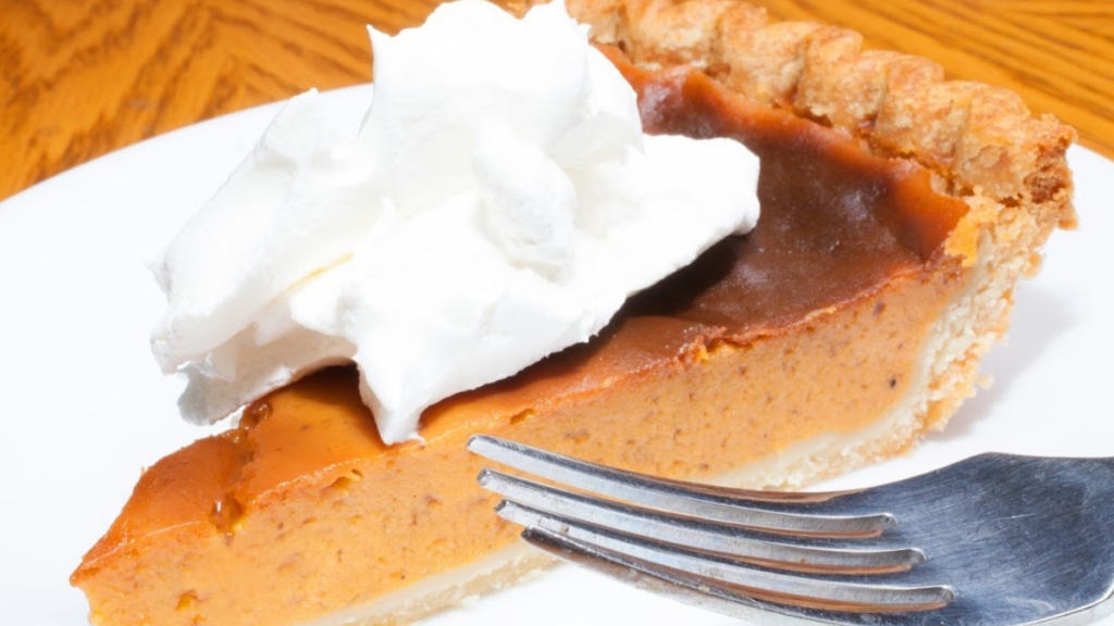 sweet potato bourbon pie with whipped cream on top on a plate