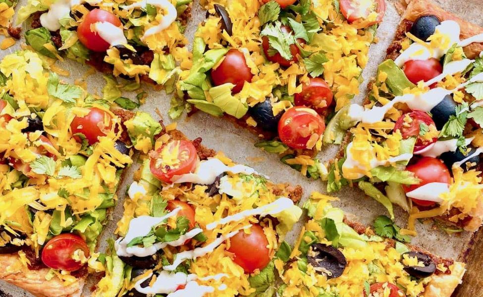 A sheet pan pizza made of taco toppings.