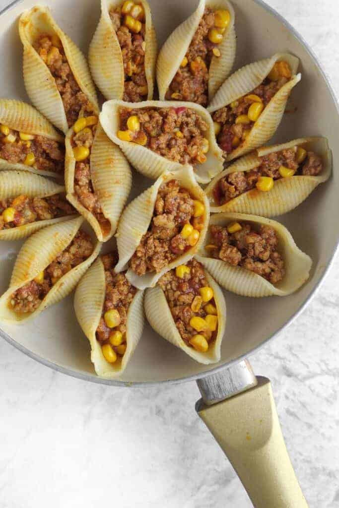 Pasta shells in a pot after being stuffed with ingredients.