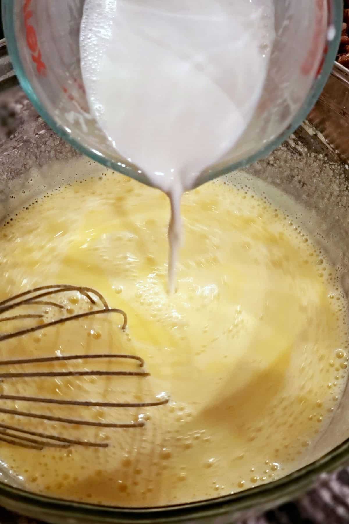 Adding milk to a bowl.