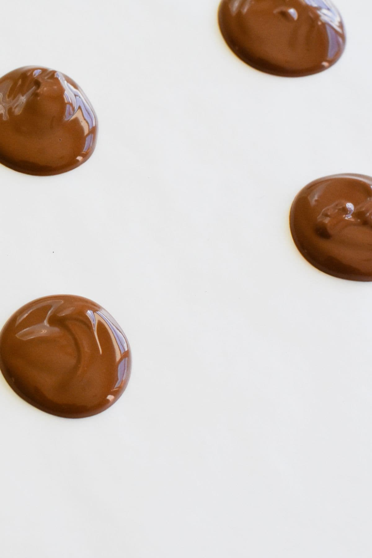 Round chocolate dots on wax paper.