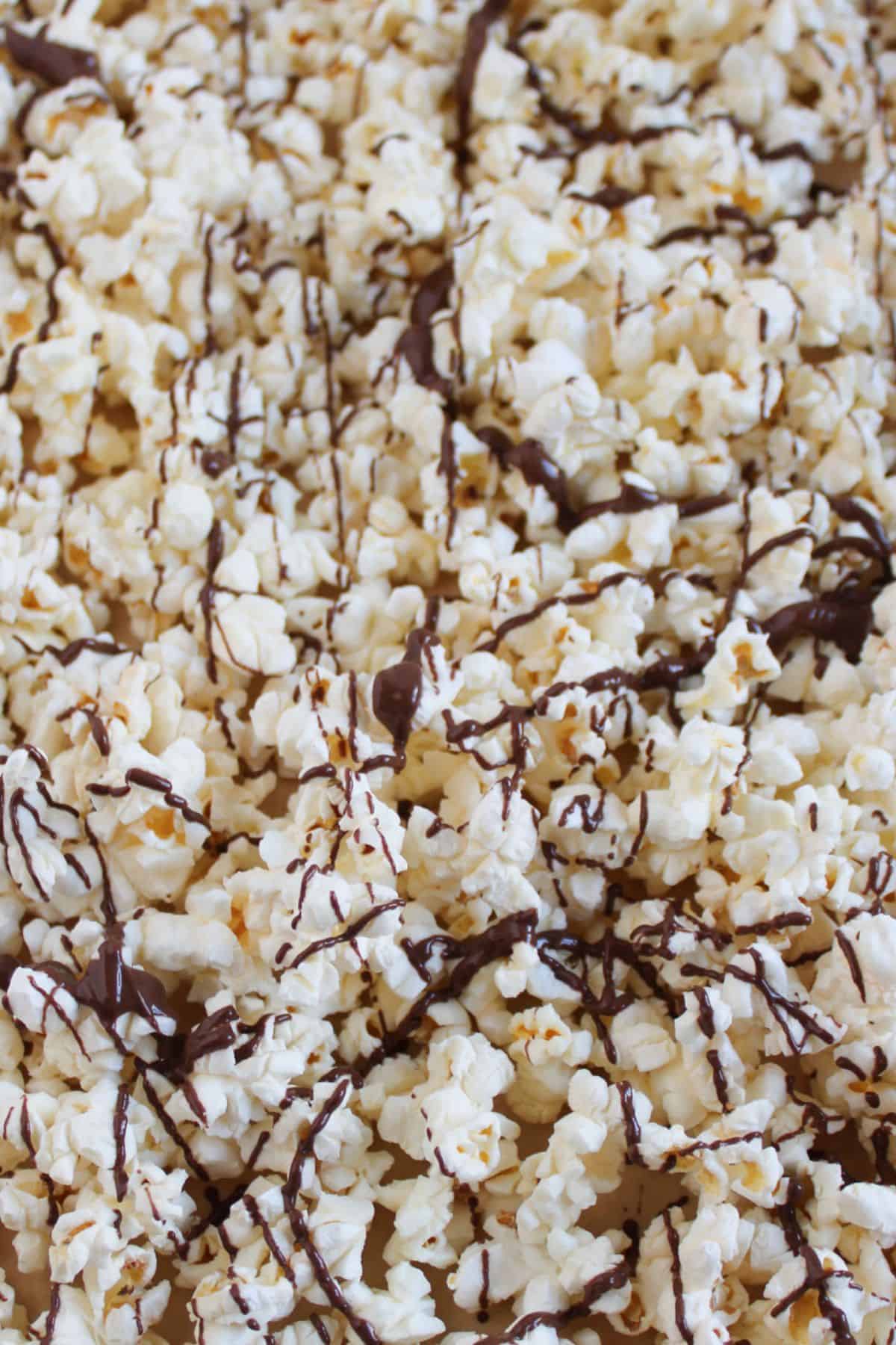 Drizzling chocolate onto popcorn.