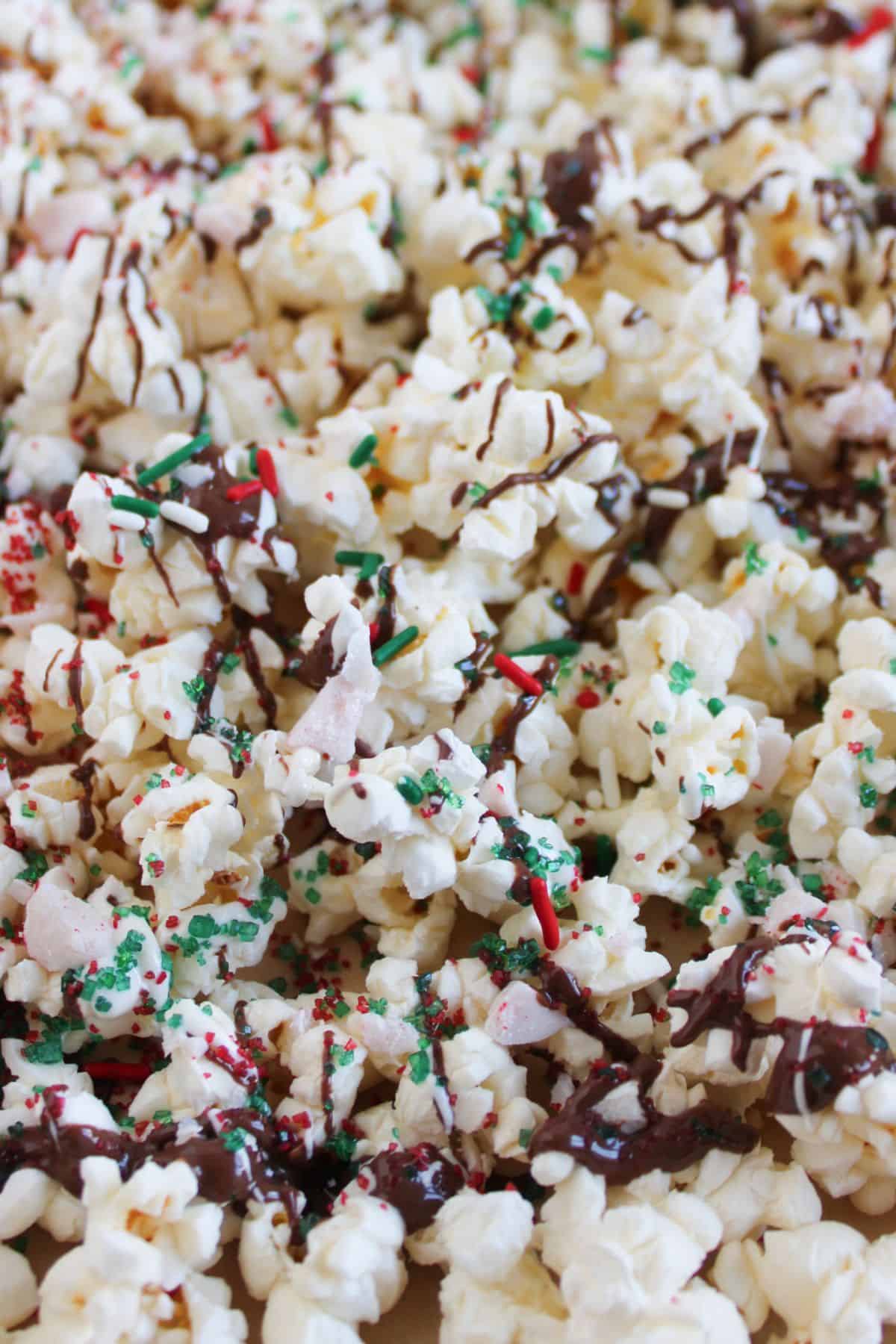 Adding sprinkles to popcorn with chocolate.